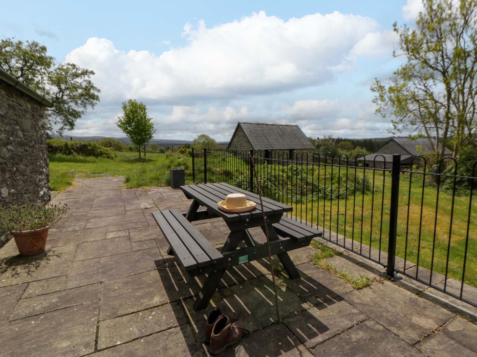 An outdoor area with a table and benches at Cwtch in Swyddffynnon near Pontrhydfendigaid