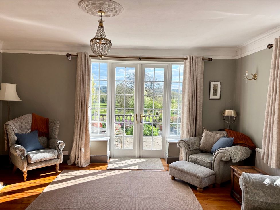 A living room with an armchair and a sofa at Humphreston House in Temple Cloud