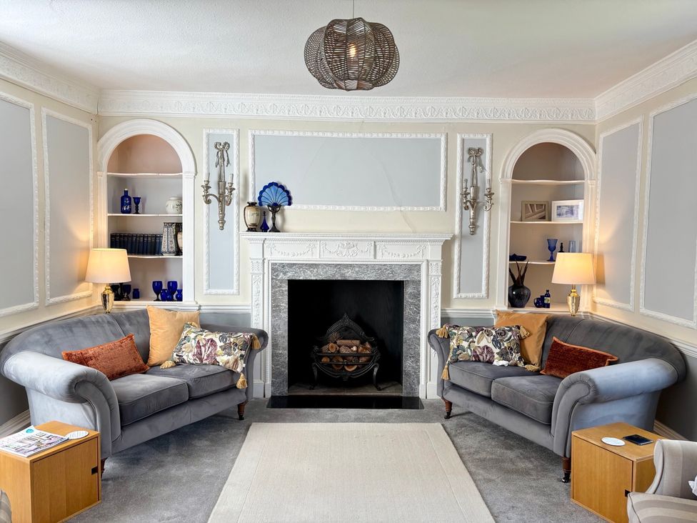 A living room with sofas and a fireplace at Humphreston House in Temple Cloud