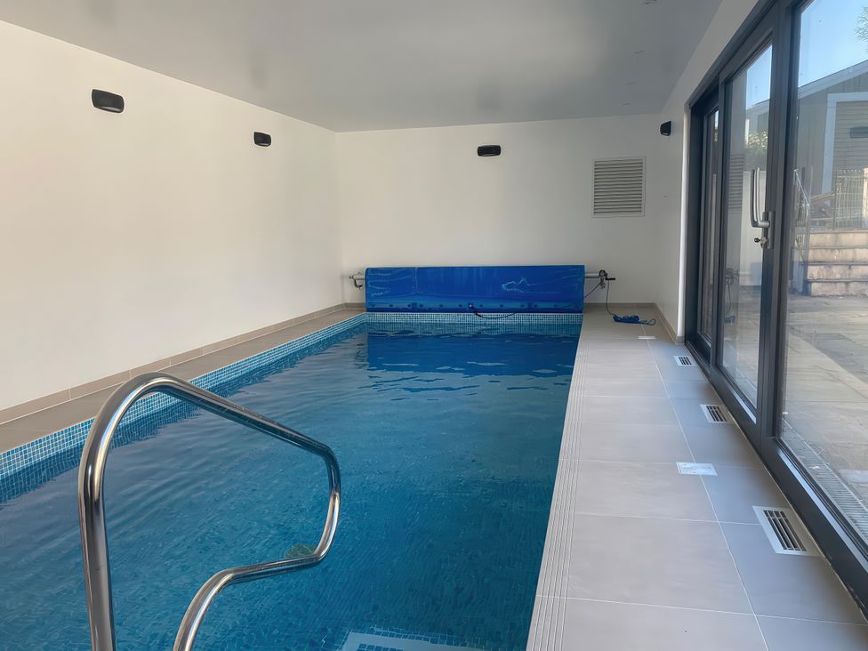 An indoor pool with a ladder and cover at Mys Hedra Farm in Penzance
