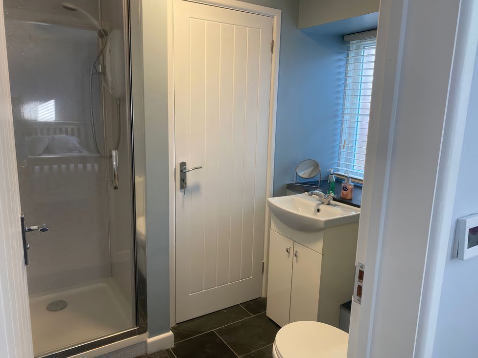 A bathroom with a shower, toilet, and sink at Mys Hedra Farm in Penzance