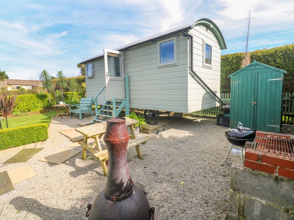 An outdoor area with a shepherd's hut and garden furniture at Higher Merther Farm Shepherds Hut Helston