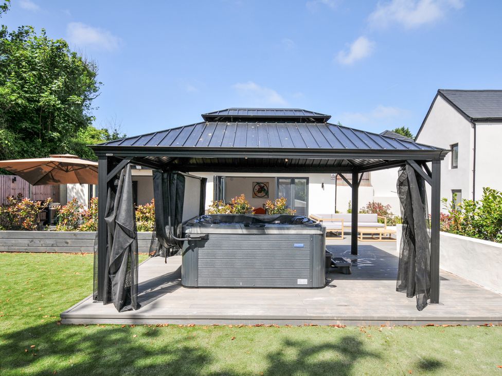 A hot tub under a gazebo in the garden at Boathyde Northam