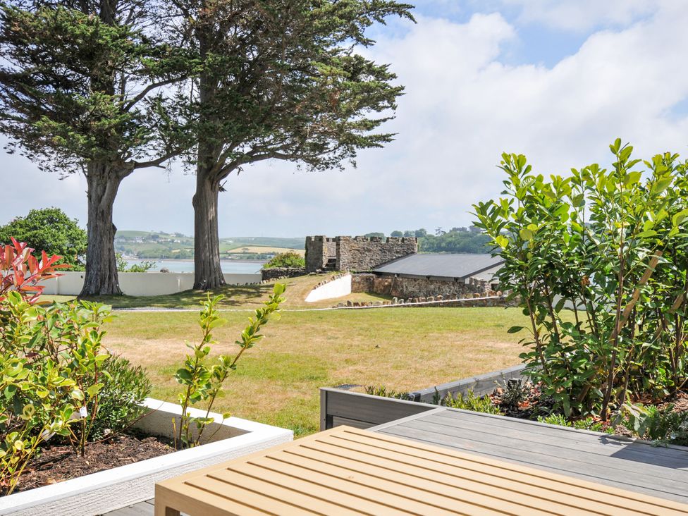 A garden with trees and a view of the water and building at Boathyde Northam