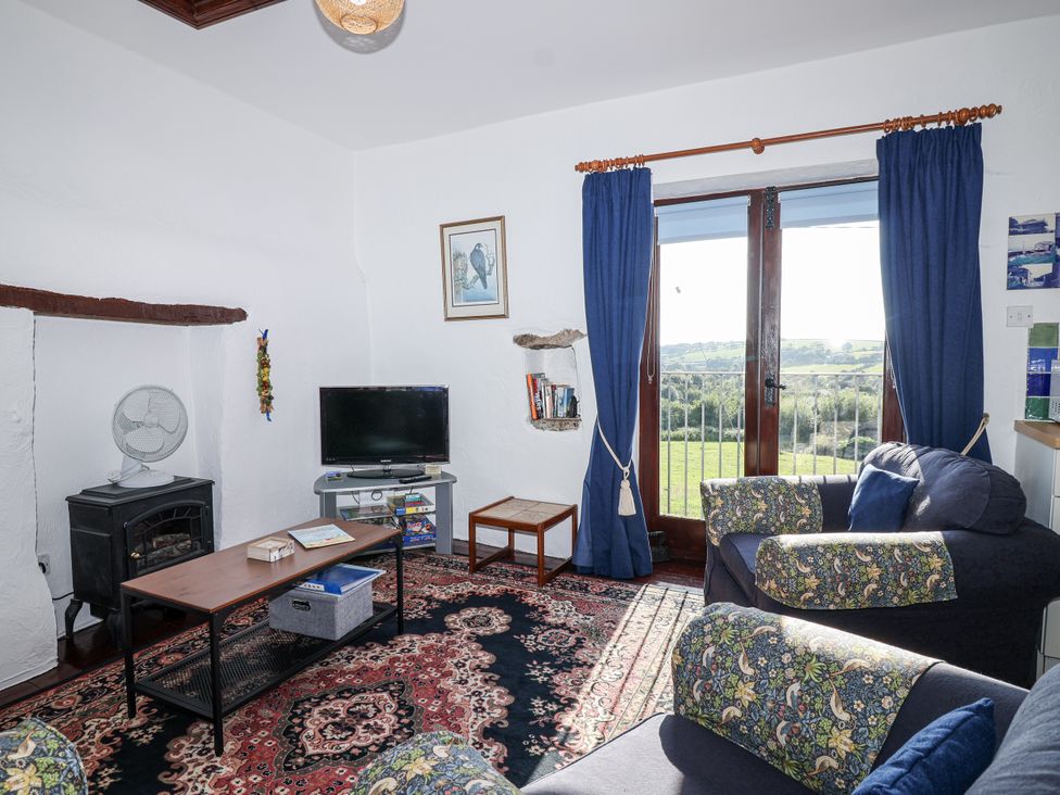A living room with a television and sofa at The Hayloft in Common Moor near Liskeard