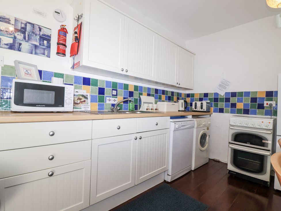 A kitchen with appliances and cabinets at The Hayloft in Common Moor near Liskeard