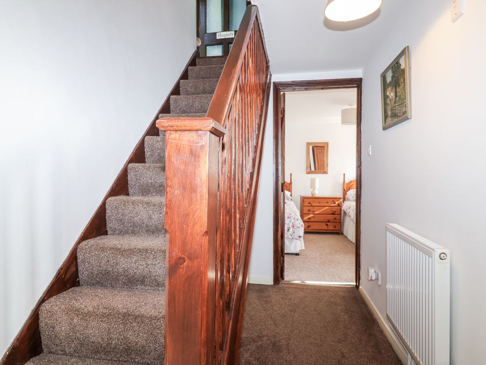 A staircase leading to bedrooms in a hallway at The Hayloft in Common Moor near Liskeard