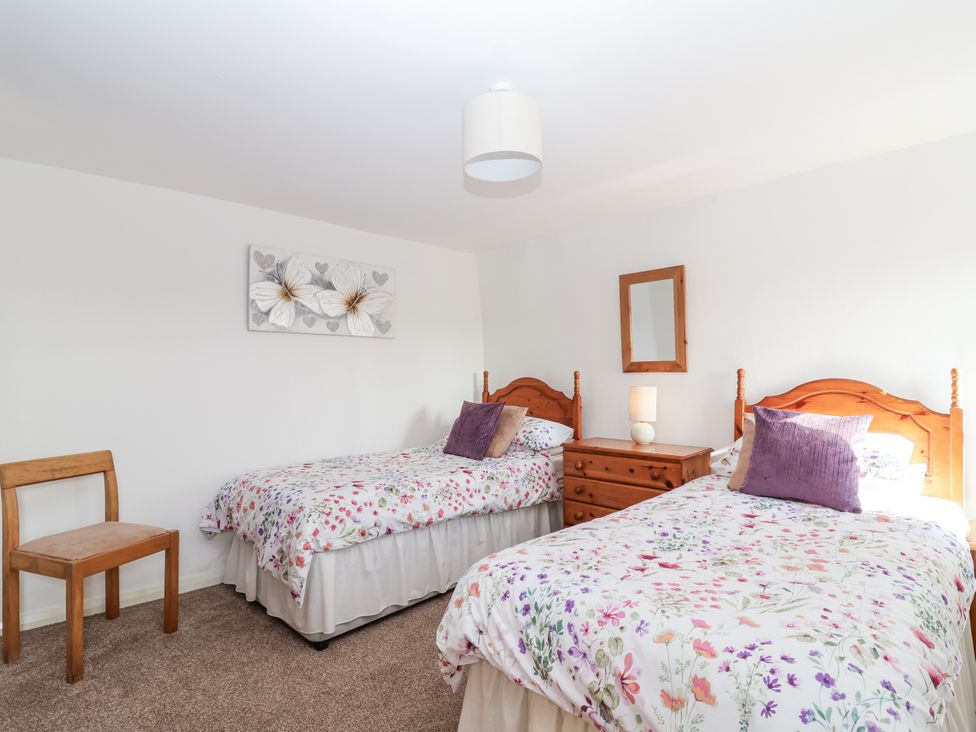 A bedroom with two single beds and a small dresser at The Hayloft Common Moor near Liskeard