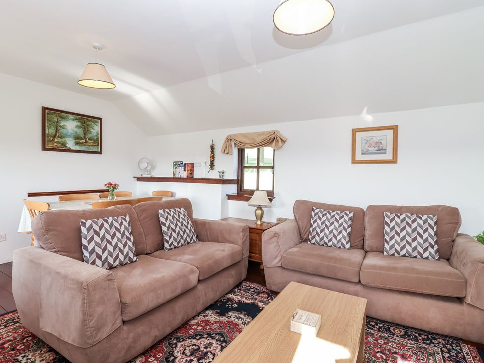 A living room with sofas and a table at The Dairy in Common Moor near Liskeard