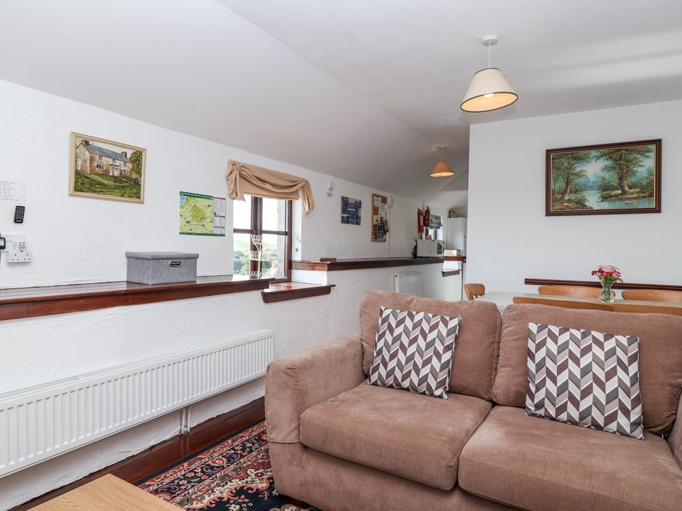A living room with a sofa and radiator at The Dairy in Common Moor near Liskeard