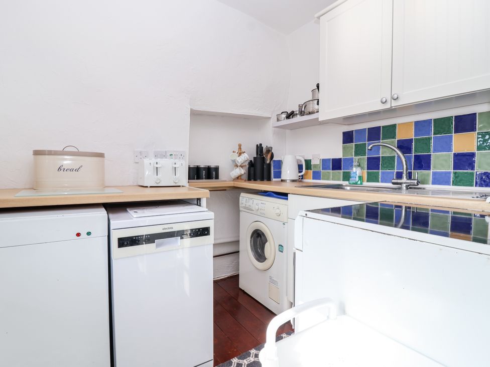 A kitchen with appliances and a tiled backsplash at The Dairy Common Moor near Liskeard