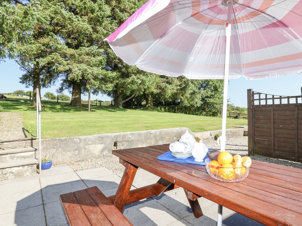 A picnic table with an umbrella and fruit bowl at The Dairy Common Moor near Liskeard