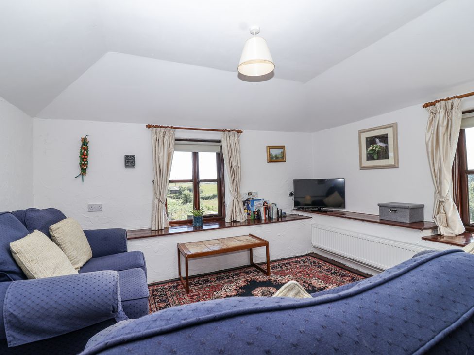 A living room with a television and sofas at The Byre in Common Moor near Liskeard