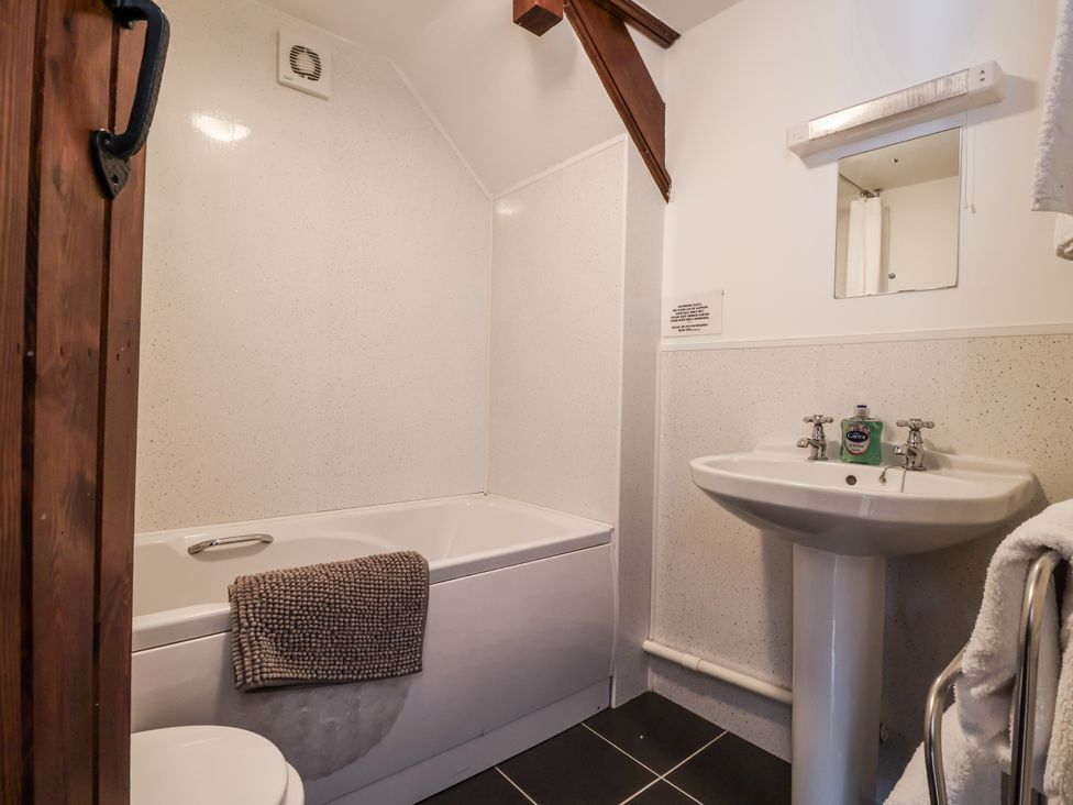 A bathroom with a bathtub, sink, and toilet at The Byre in Common Moor near Liskeard