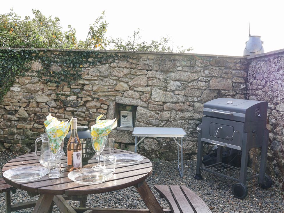 A table set with plates and glasses near a grill at The Byre Common Moor near Liskeard
