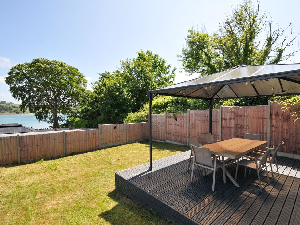 A garden with a table and chairs under a gazebo at The Mooring in Northam