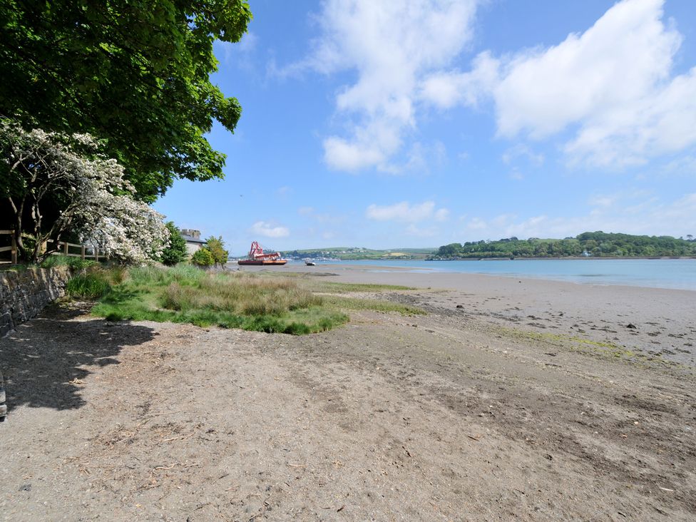 A beach with water and trees at The Mooring in Northam
