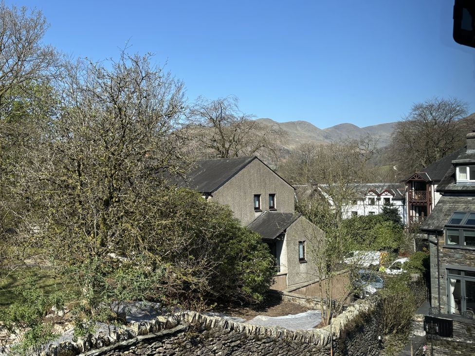 A view of houses and trees with mountains in the background at Rothay Cottage Ambleside