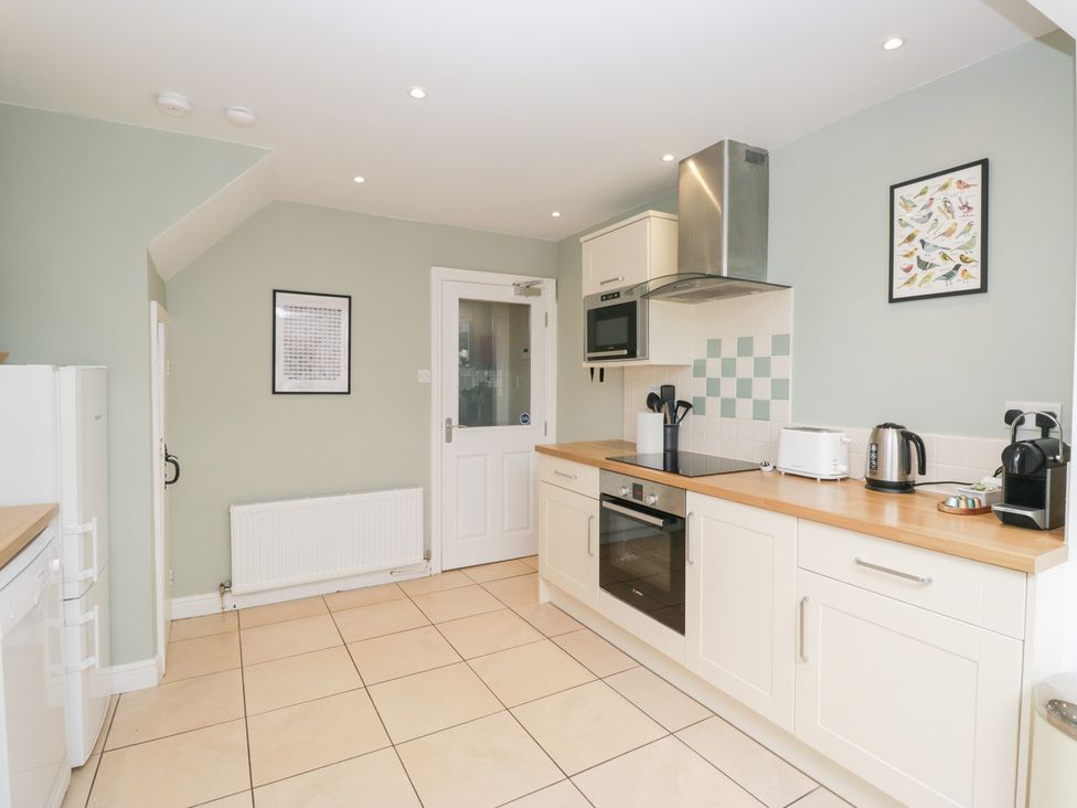 A kitchen with appliances and a door at Rothay Cottage Ambleside