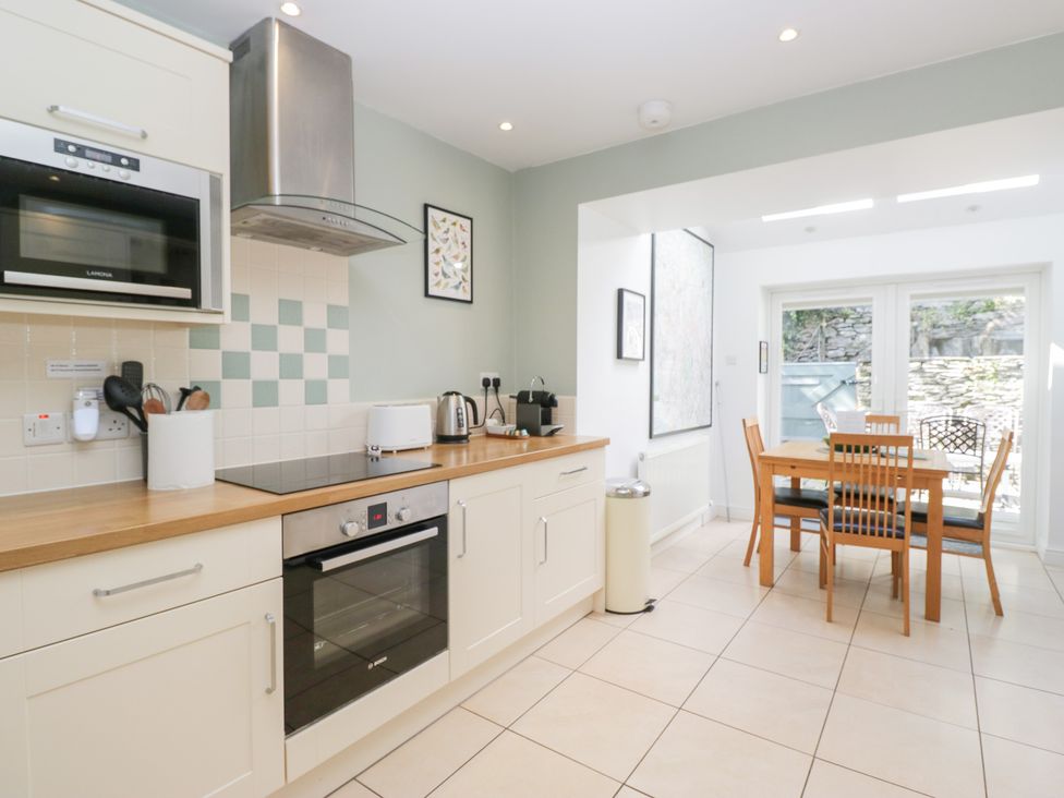 A kitchen with appliances and dining area at Rothay Cottage Ambleside