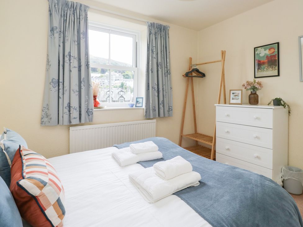 A bedroom with a bed and dresser at Rothay Cottage in Ambleside