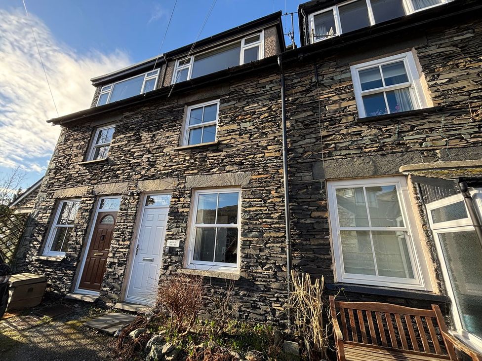 A stone house with front doors and windows at Rothay Cottage in Ambleside