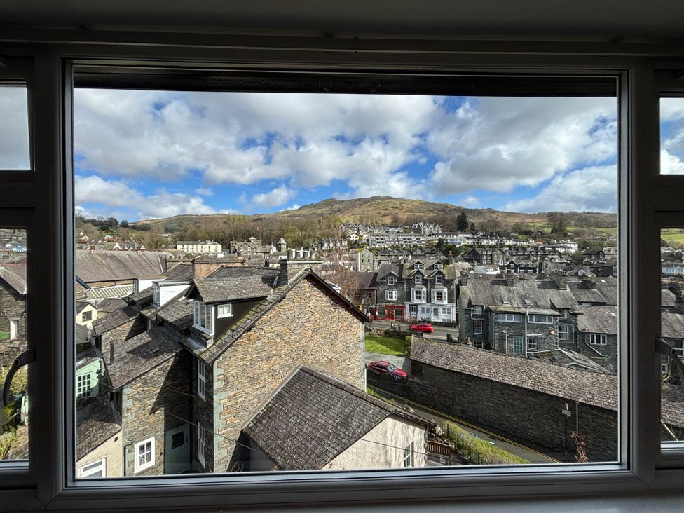 A view of houses and hills from a window at Rothay Cottage Ambleside