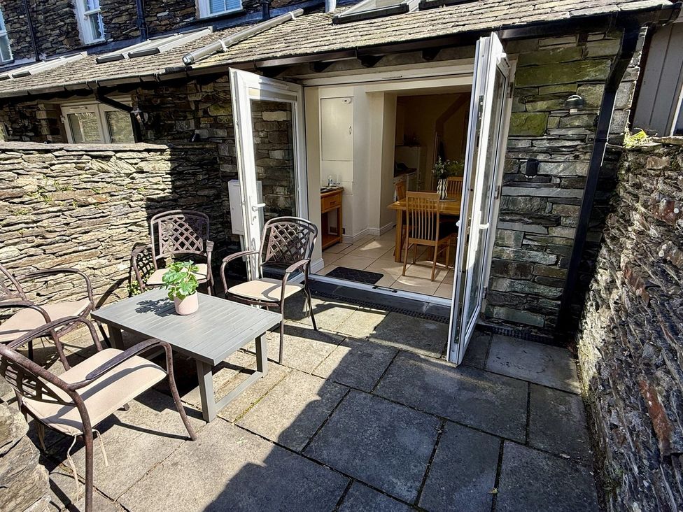 An outdoor patio with a table and chairs at Rothay Cottage in Ambleside