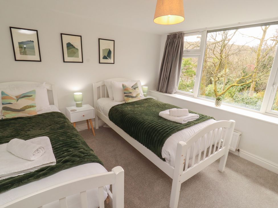 A bedroom with two beds and a window at Rothay Cottage in Ambleside