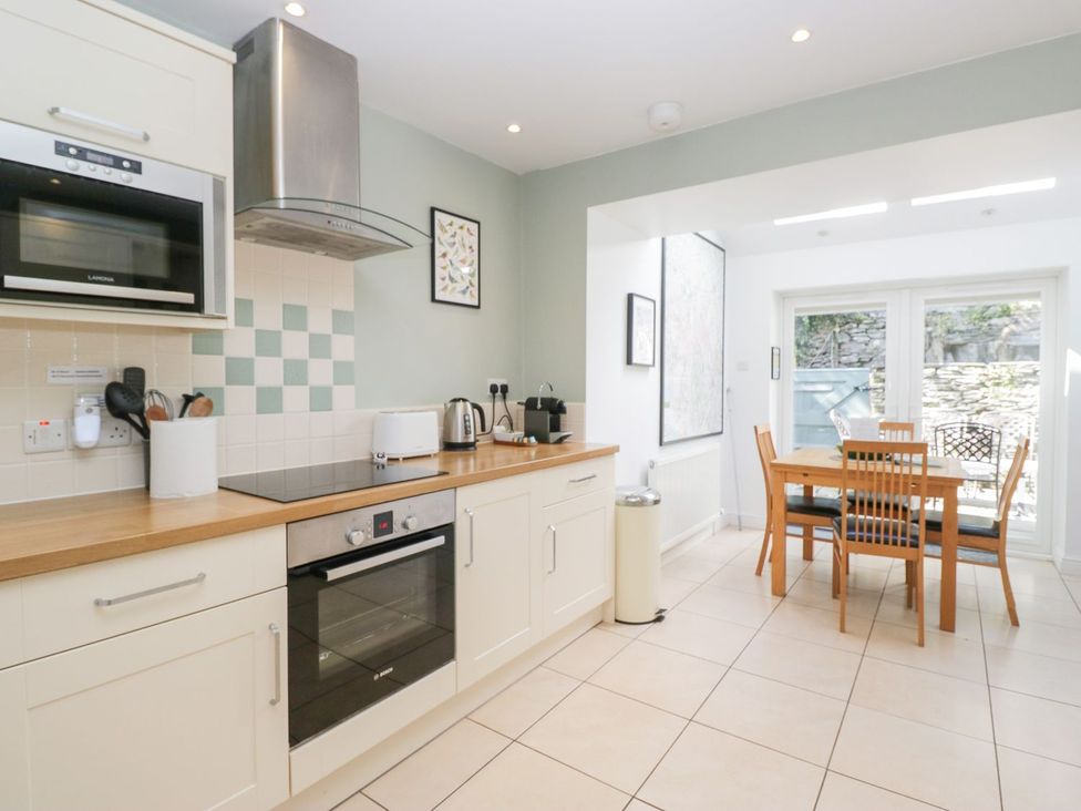 A kitchen with appliances and dining table at Rothay Cottage in Ambleside