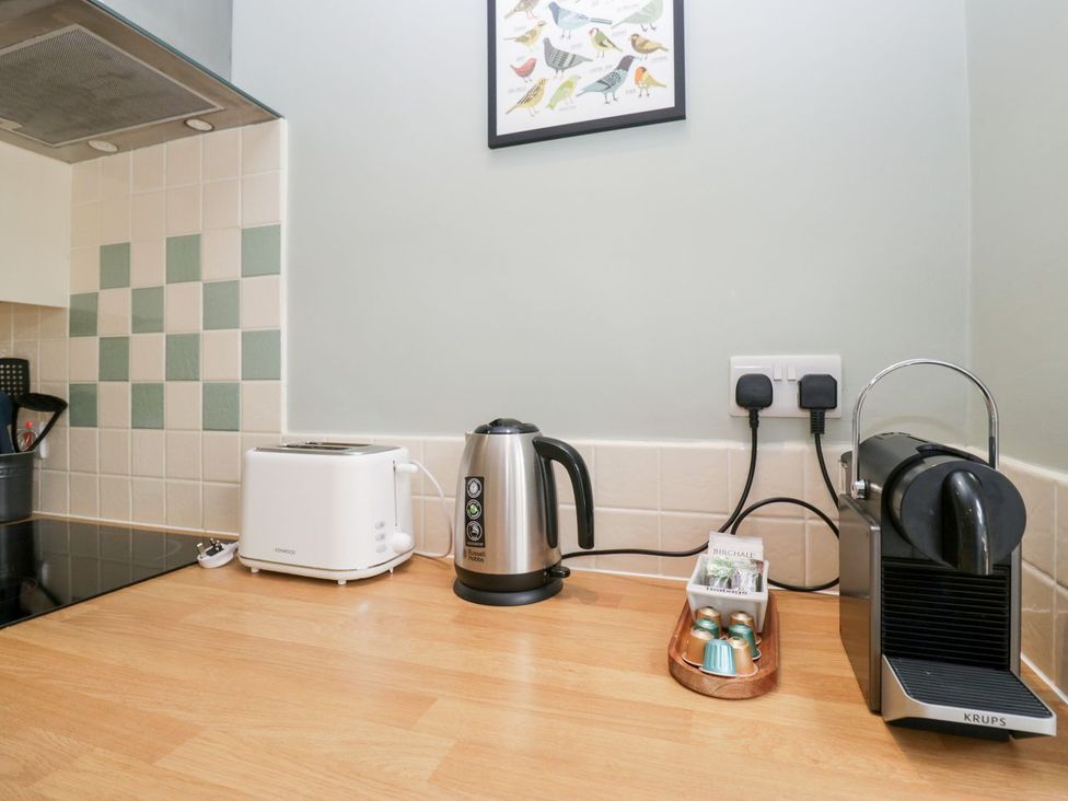 A kitchen counter with a toaster, kettle, and coffee machine at Rothay Cottage in Ambleside