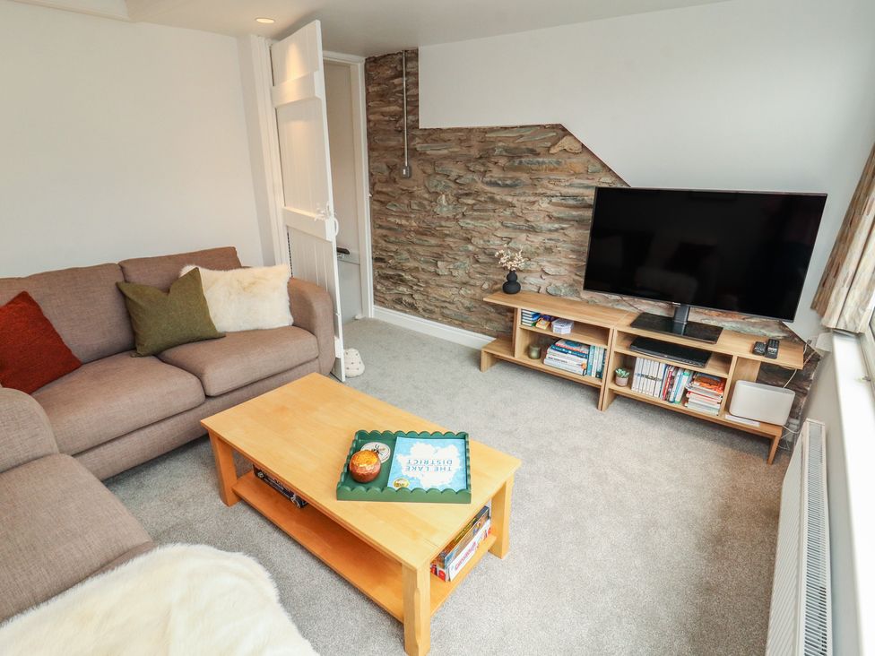 A living room with a sofa and television at Rothay Cottage in Ambleside