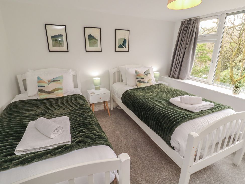 A bedroom with two beds and a window at Rothay Cottage in Ambleside