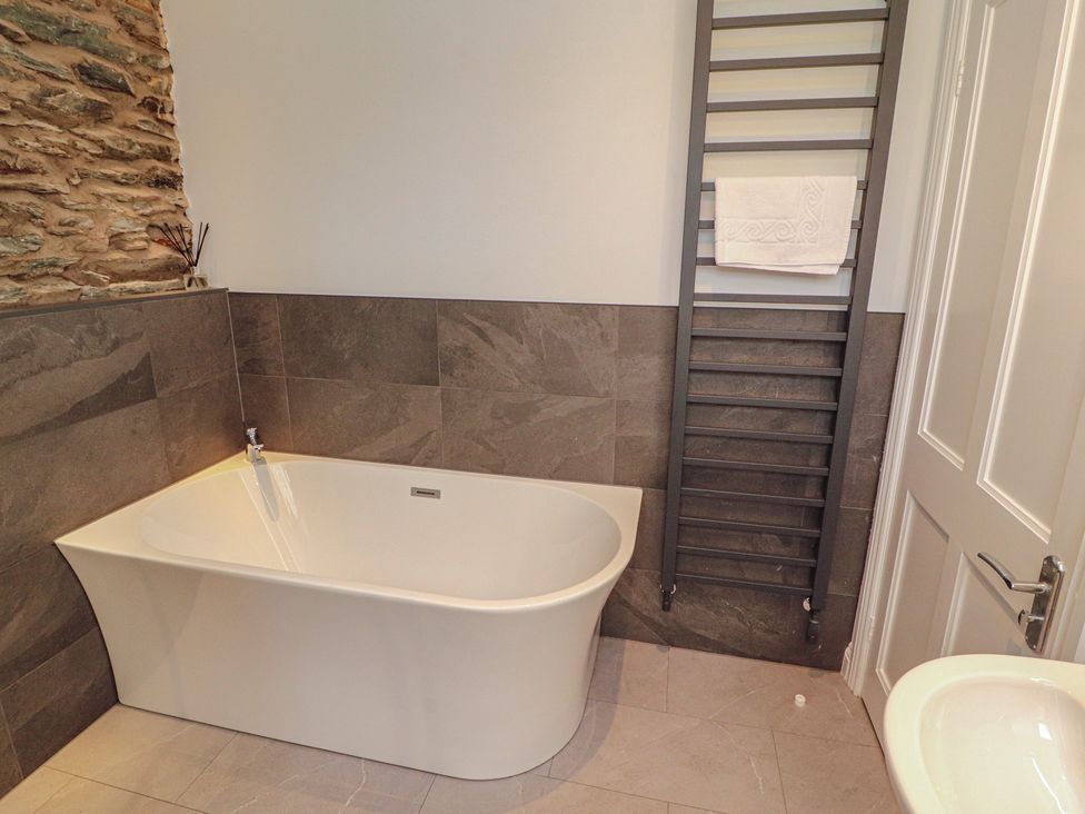 A bathroom featuring a bathtub and towel rail at Rothay Cottage Ambleside