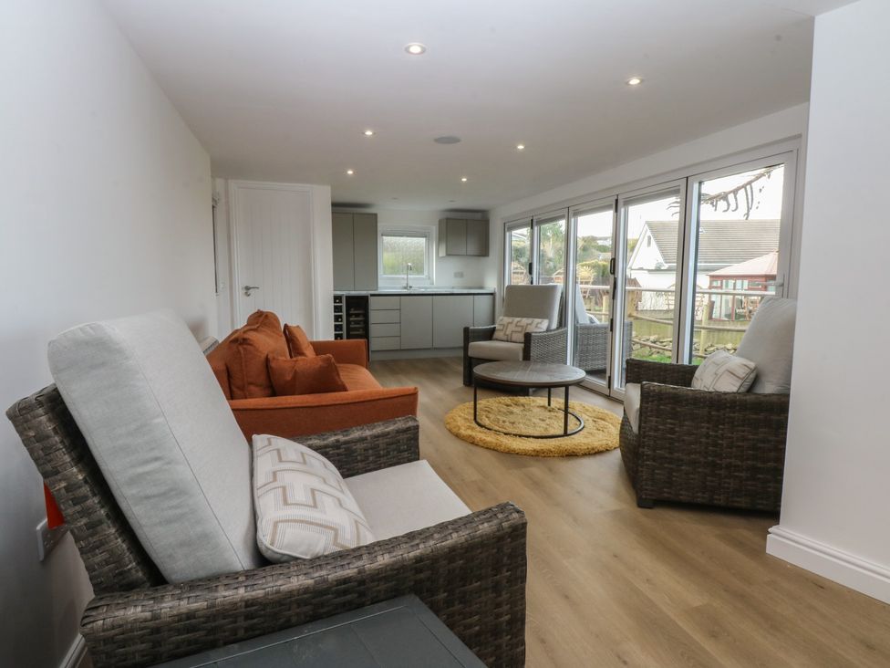 A sunroom with seating and kitchen area at The Bay in Benllech