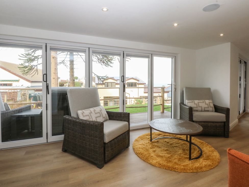 A living room with chairs and a table at The Bay in Benllech
