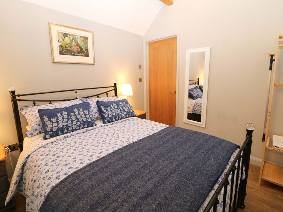 A bedroom with a bed and side table at Horsedale Barn in Bonsall