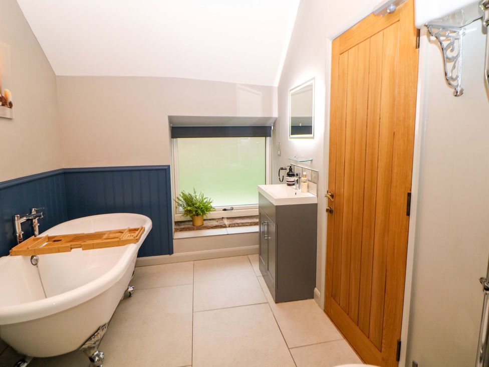 A bathroom with a bathtub and vanity at Horsedale Barn in Bonsall