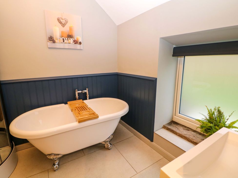 A bathroom with a bathtub and window at Horsedale Barn in Bonsall