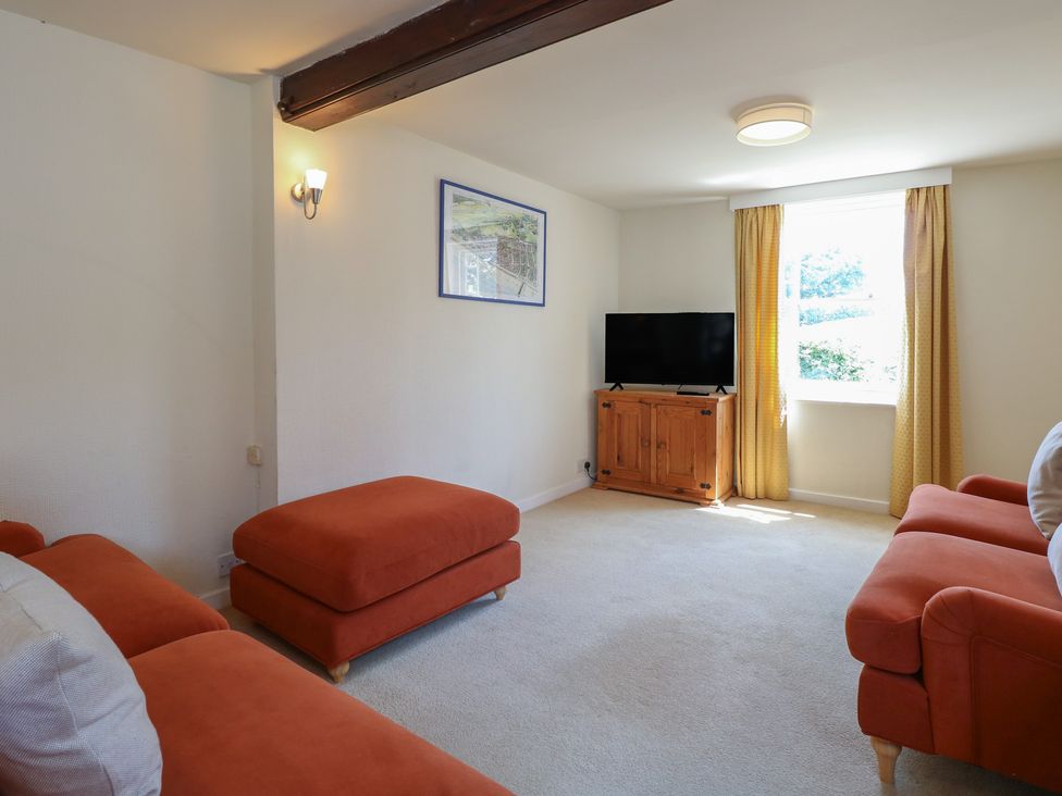 A living room with a television and a sofa at Iona Cottage in Southwold