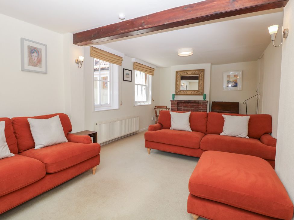 A living room with sofas and a fireplace at Iona Cottage Southwold