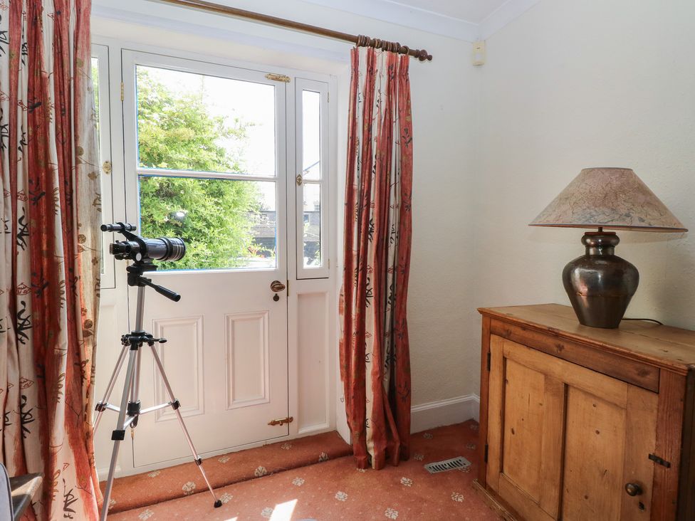 A room with a window and a camera on a tripod at Iona Cottage Southwold