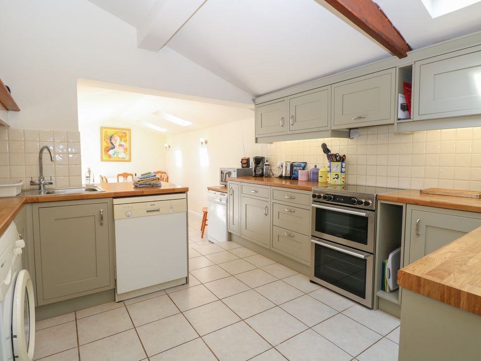 A kitchen with cabinets and appliances at Iona Cottage in Southwold