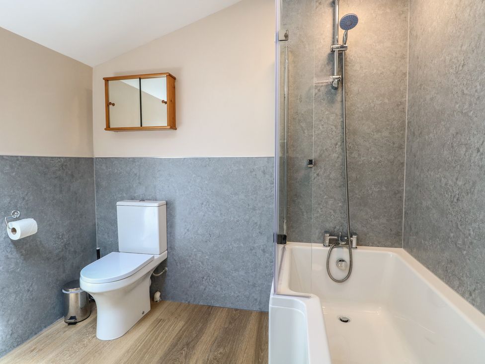 A bathroom with a bathtub and toilet at Iona Cottage Southwold