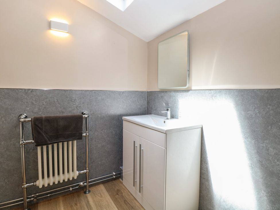 A bathroom with a sink and towel radiator at Iona Cottage Southwold