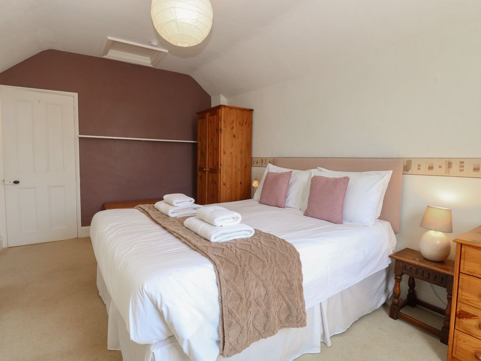 A bedroom with a double bed and wardrobe at Iona Cottage Southwold