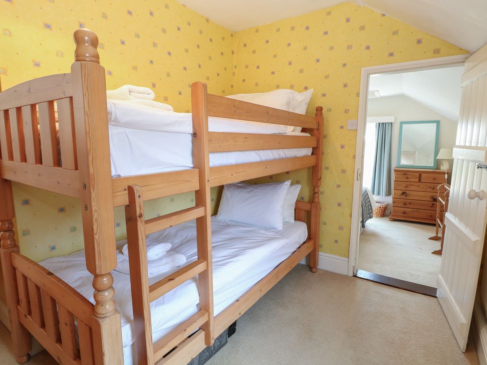 A bedroom with a bunk bed and dresser at Iona Cottage Southwold
