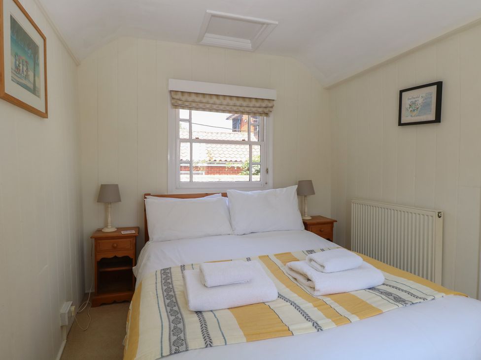 A bedroom with a double bed and bedside table at Iona Cottage Southwold