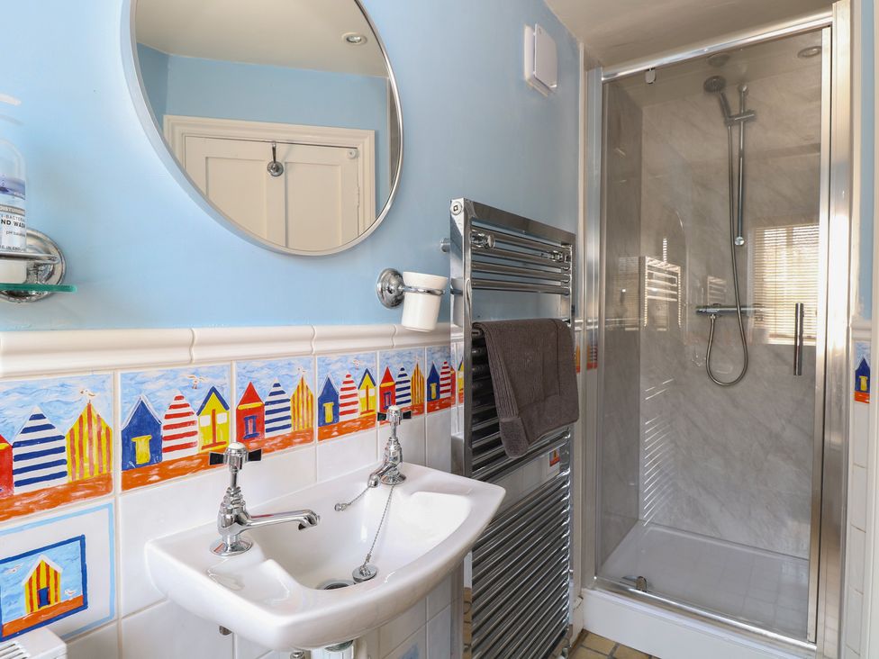 A bathroom with sink and shower at Iona Cottage in Southwold
