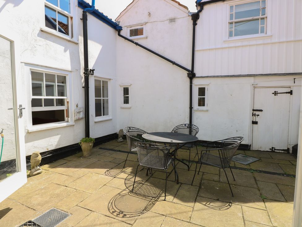 An outdoor patio area with a table and chairs at Iona Cottage Southwold